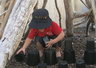 Vision and values gallery, child playing with plant pots